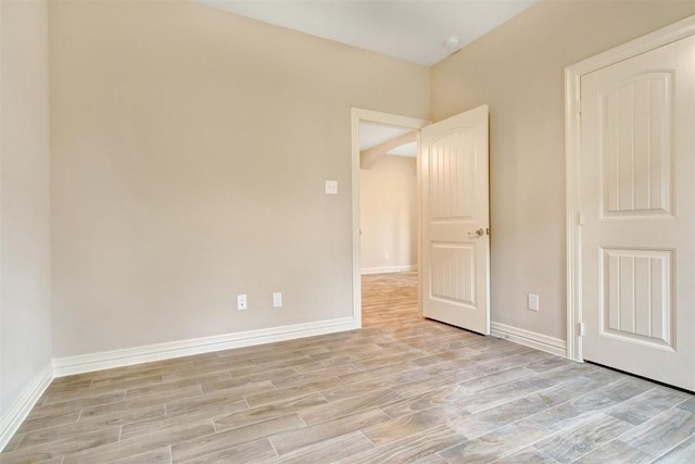 1805 Rollingwood Dr, Huntsville, TX 77340 - spare room featuring light wood finished floors, arched walkways, baseboards, and a smoke detector