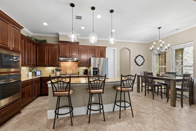 29122 Champions Dr, Magnolia, TX 77355 - kitchen featuring stainless steel appliances, arched walkways, under cabinet range hood, decorative backsplash, and a chandelier