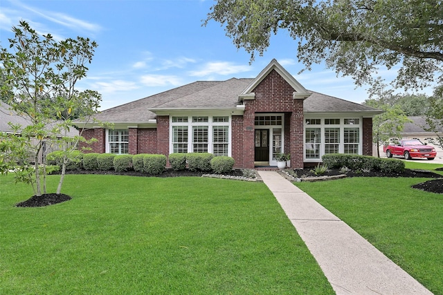 1405 Blueberry Ln, Friendswood, TX 77546 - view of front of home featuring brick siding, a front yard, and a shingled roof