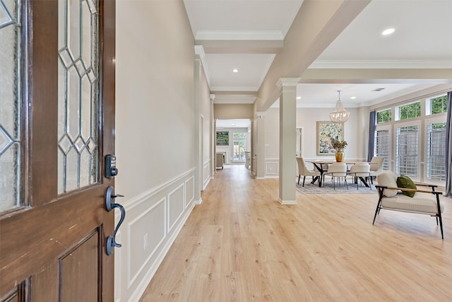 1405 Blueberry Ln, Friendswood, TX 77546 - entryway with ornamental molding, light wood-style floors, a decorative wall, wainscoting, and a chandelier