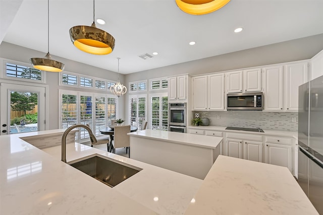 1405 Blueberry Ln, Friendswood, TX 77546 - kitchen with appliances with stainless steel finishes, a sink, tasteful backsplash, white cabinetry, and recessed lighting