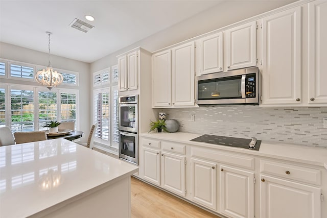 1405 Blueberry Ln, Friendswood, TX 77546 - kitchen with appliances with stainless steel finishes, tasteful backsplash, a chandelier, light countertops, and recessed lighting