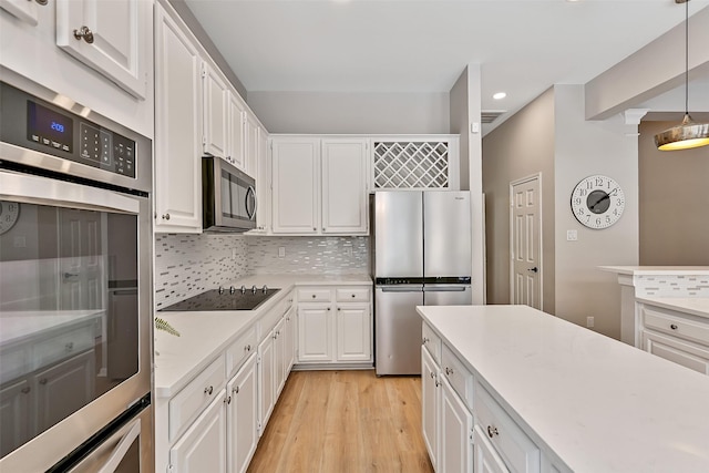 1405 Blueberry Ln, Friendswood, TX 77546 - kitchen featuring appliances with stainless steel finishes, recessed lighting, light countertops, light wood-type flooring, and decorative backsplash