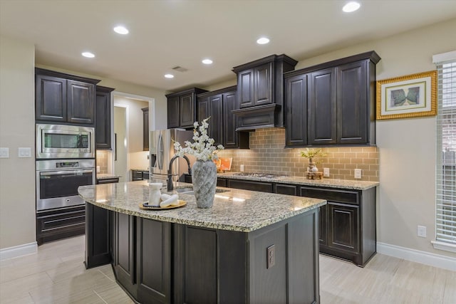 16815 Bornish Hill Ct, Humble, TX 77346 - kitchen featuring appliances with stainless steel finishes, tasteful backsplash, baseboards, light stone countertops, and recessed lighting