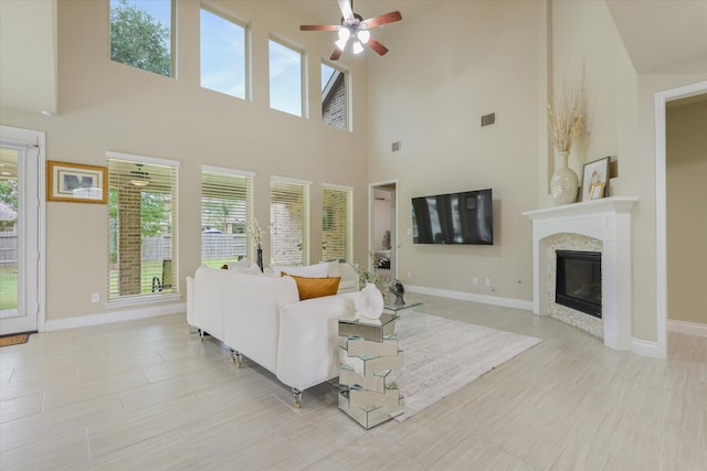 16815 Bornish Hill Ct, Humble, TX 77346 - living room featuring plenty of natural light, a ceiling fan, a high ceiling, and a glass covered fireplace