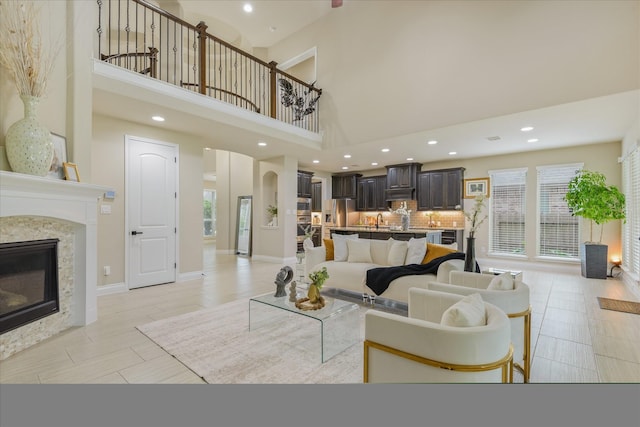 16815 Bornish Hill Ct, Humble, TX 77346 - living area featuring a towering ceiling, a glass covered fireplace, recessed lighting, and baseboards