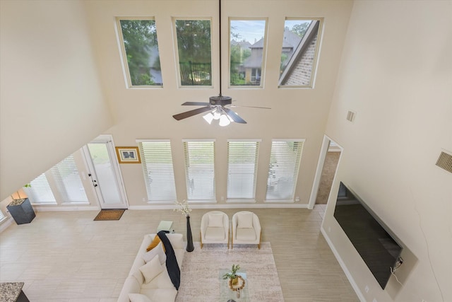 16815 Bornish Hill Ct, Humble, TX 77346 - living room with ceiling fan, a towering ceiling, and baseboards