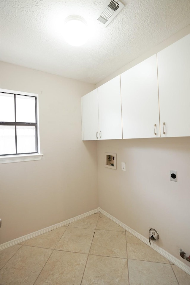 14106 Glen Canon Ln, Houston, TX 77069 - washroom with electric dryer hookup, washer hookup, cabinet space, light tile patterned flooring, and baseboards