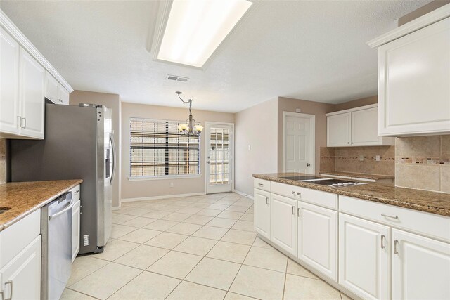 14106 Glen Canon Ln, Houston, TX 77069 - kitchen featuring stainless steel appliances, decorative backsplash, a chandelier, white cabinetry, and light tile patterned floors