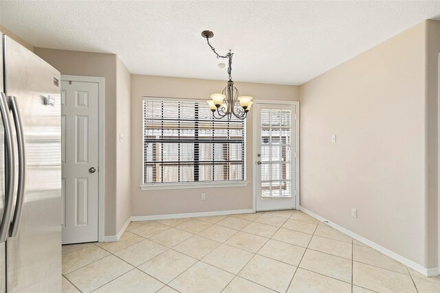 14106 Glen Canon Ln, Houston, TX 77069 - unfurnished dining area with a chandelier, a textured ceiling, light tile patterned flooring, and baseboards