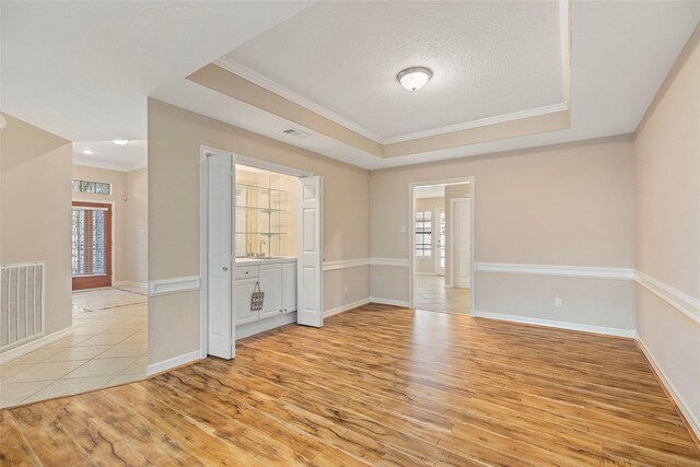 14106 Glen Canon Ln, Houston, TX 77069 - unfurnished room featuring a tray ceiling, crown molding, light wood finished floors, baseboards, and a textured ceiling