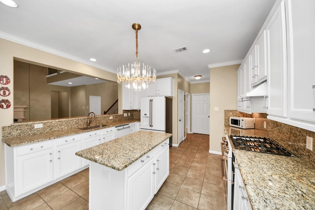 20902 Montana Bend Ln, Cypress, TX 77433 - kitchen with white appliances, a sink, light tile patterned floors, a chandelier, and a center island