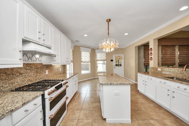 20902 Montana Bend Ln, Cypress, TX 77433 - kitchen with double oven range, a kitchen island, a chandelier, a sink, and tasteful backsplash