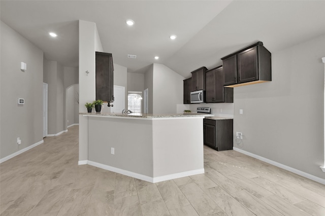 115 Clear Water St W, Montgomery, TX 77356 - kitchen with appliances with stainless steel finishes, arched walkways, dark brown cabinetry, lofted ceiling, and baseboards
