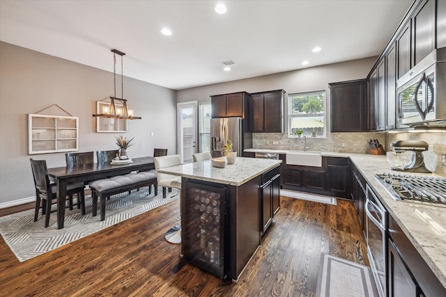 1115 E 27th St, Houston, TX 77009 - kitchen with stainless steel appliances, dark wood finished floors, beverage cooler, healthy amount of natural light, and recessed lighting