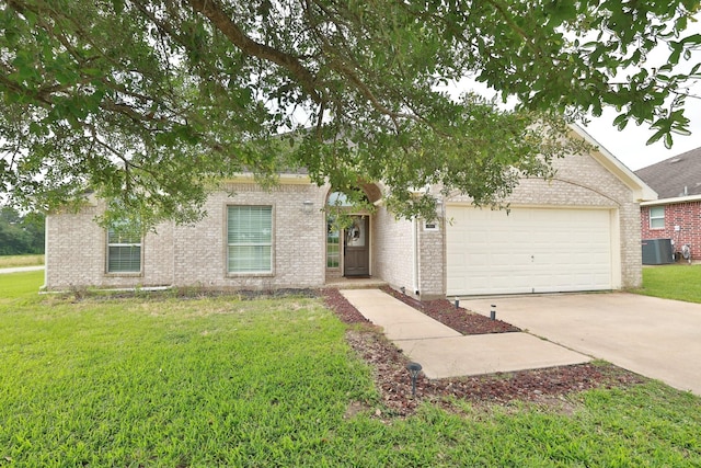 301 Redwood St, Prairie View, TX 77445 - view of property hidden behind natural elements with central air condition unit, a garage, concrete driveway, a front yard, and brick siding