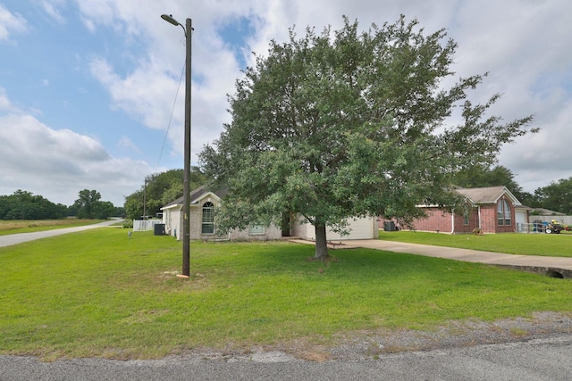 301 Redwood St, Prairie View, TX 77445 - obstructed view of property with brick siding, concrete driveway, a front lawn, and a garage