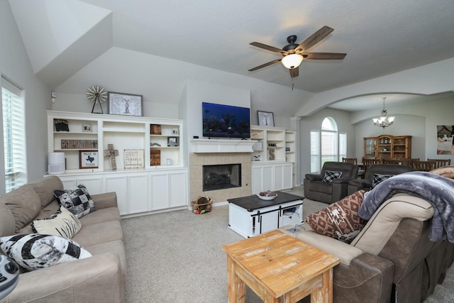 301 Redwood St, Prairie View, TX 77445 - carpeted living room with arched walkways, a ceiling fan, a chandelier, a tile fireplace, and lofted ceiling
