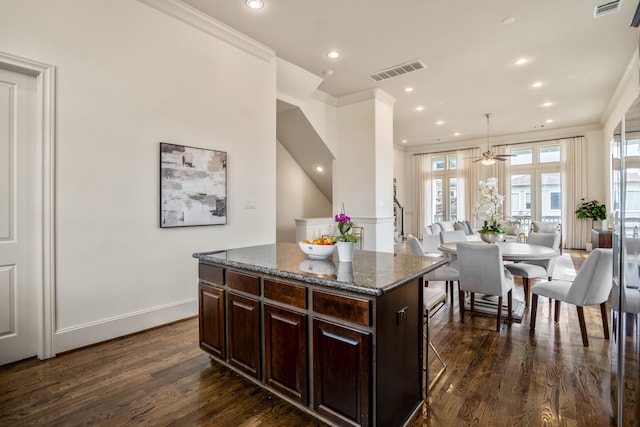 1217 E 28th St, Houston, TX 77009 - kitchen featuring ornamental molding, dark wood-style floors, a kitchen island, recessed lighting, and dark brown cabinets
