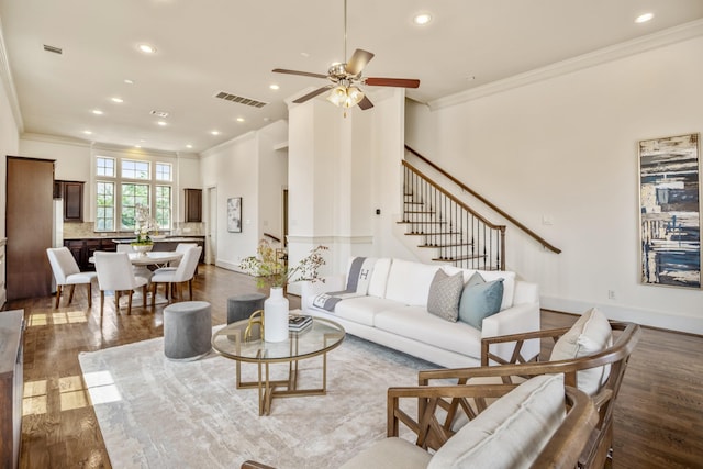 1217 E 28th St, Houston, TX 77009 - living room with crown molding, dark wood-style floors, recessed lighting, ceiling fan, and stairway