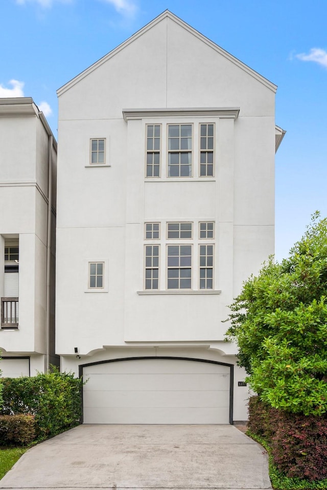 1217 E 28th St, Houston, TX 77009 - view of front of property featuring a garage, stucco siding, and concrete driveway