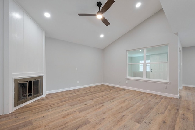 10260 Field Stone, Houston, TX 77041 - unfurnished living room with ceiling fan, lofted ceiling, a glass covered fireplace, light wood-style floors, and baseboards