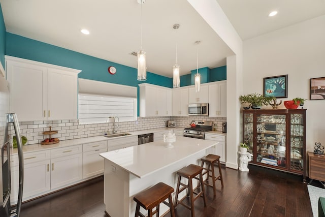 2210 Lou Ellen Ln Unit F, Houston, TX 77018 - kitchen featuring stainless steel appliances, a sink, a breakfast bar area, decorative backsplash, and white cabinets