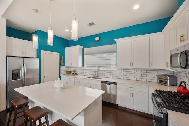 2210 Lou Ellen Ln Unit F, Houston, TX 77018 - kitchen featuring stainless steel appliances, a sink, tasteful backsplash, a kitchen breakfast bar, and white cabinetry