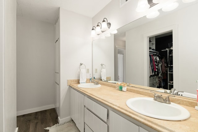 402 Teakwood Dr, Victoria, TX 77901 - full bath with wood finished floors, double vanity, a walk in closet, and baseboards