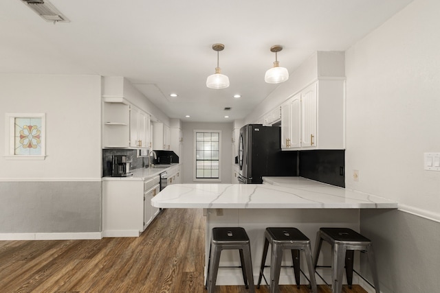 402 Teakwood Dr, Victoria, TX 77901 - kitchen with a sink, a peninsula, white cabinets, open shelves, and light stone counters