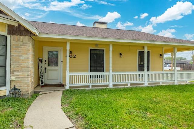 402 Teakwood Dr, Victoria, TX 77901 - property entrance with a porch, a lawn, a chimney, and roof with shingles