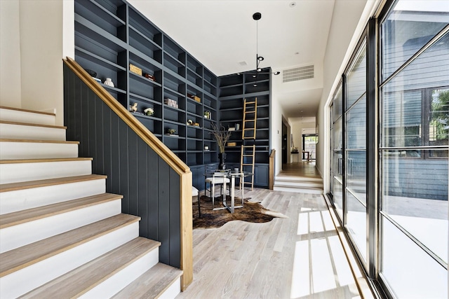 703 E 9th St, Houston, TX 77007 - staircase with wood finished floors, a high ceiling, and built in shelves