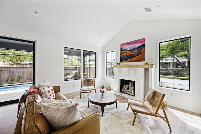703 E 9th St, Houston, TX 77007 - living area with healthy amount of natural light, vaulted ceiling, baseboards, and a fireplace with flush hearth