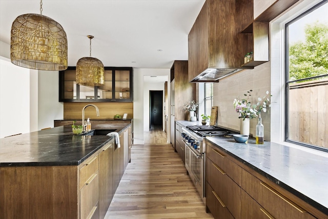 703 E 9th St, Houston, TX 77007 - kitchen featuring a sink, stainless steel stove, open shelves, light wood finished floors, and tasteful backsplash