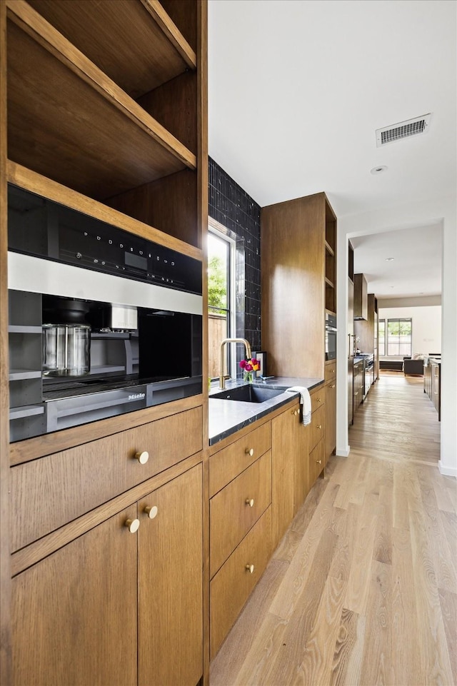 703 E 9th St, Houston, TX 77007 - kitchen with open shelves, a sink, and light wood-type flooring