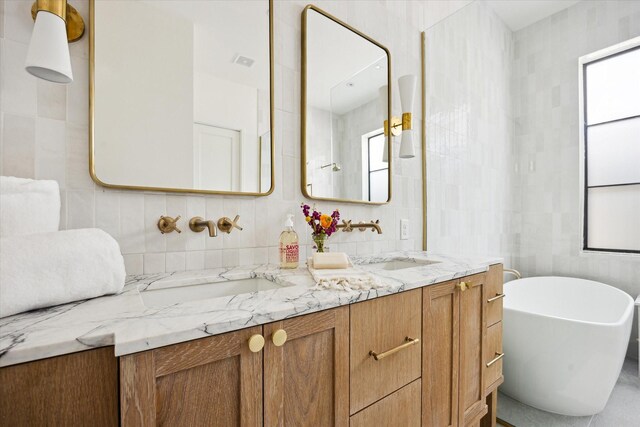 703 E 9th St, Houston, TX 77007 - full bathroom with double vanity, tile walls, a soaking tub, and decorative backsplash