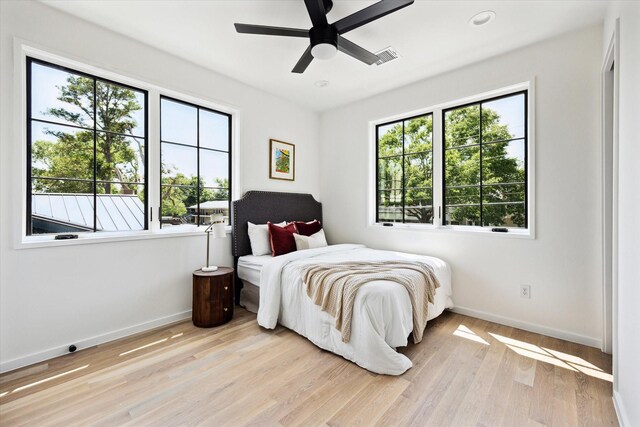 703 E 9th St, Houston, TX 77007 - bedroom featuring baseboards, light wood finished floors, and a ceiling fan