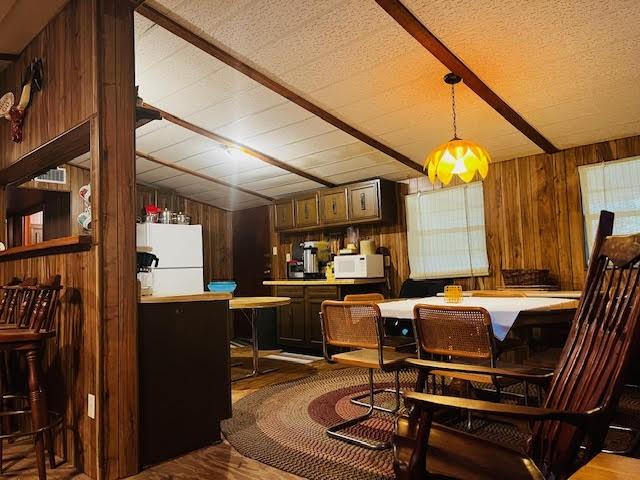 11200 Leisure Rd, Brenham, TX 77833 - dining space featuring wood walls, wood finished floors, and beam ceiling