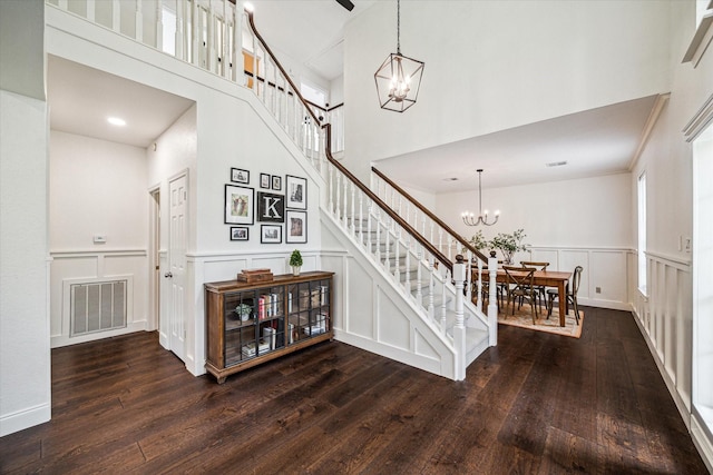 1318 N Gabriel River Cir, Sugar Land, TX 77478 - stairs featuring a chandelier, a decorative wall, hardwood / wood-style flooring, a high ceiling, and a wainscoted wall