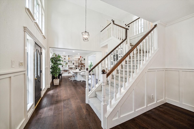 1318 N Gabriel River Cir, Sugar Land, TX 77478 - foyer entrance with a decorative wall, dark wood-type flooring, stairway, a chandelier, and a wainscoted wall