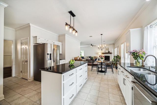 1318 N Gabriel River Cir, Sugar Land, TX 77478 - kitchen featuring stainless steel appliances, a sink, a kitchen island, ornamental molding, and light tile patterned floors