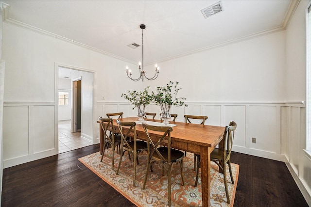 1318 N Gabriel River Cir, Sugar Land, TX 77478 - dining area with a decorative wall, dark wood-type flooring, crown molding, a chandelier, and a wainscoted wall