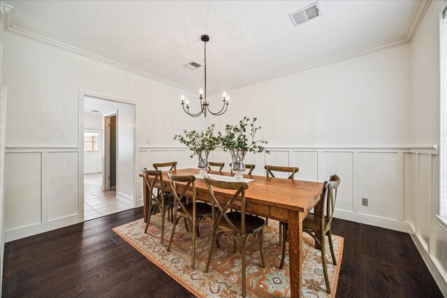 1318 N Gabriel River Cir, Sugar Land, TX 77478 - dining area featuring a decorative wall, dark wood-type flooring, ornamental molding, a chandelier, and wainscoting