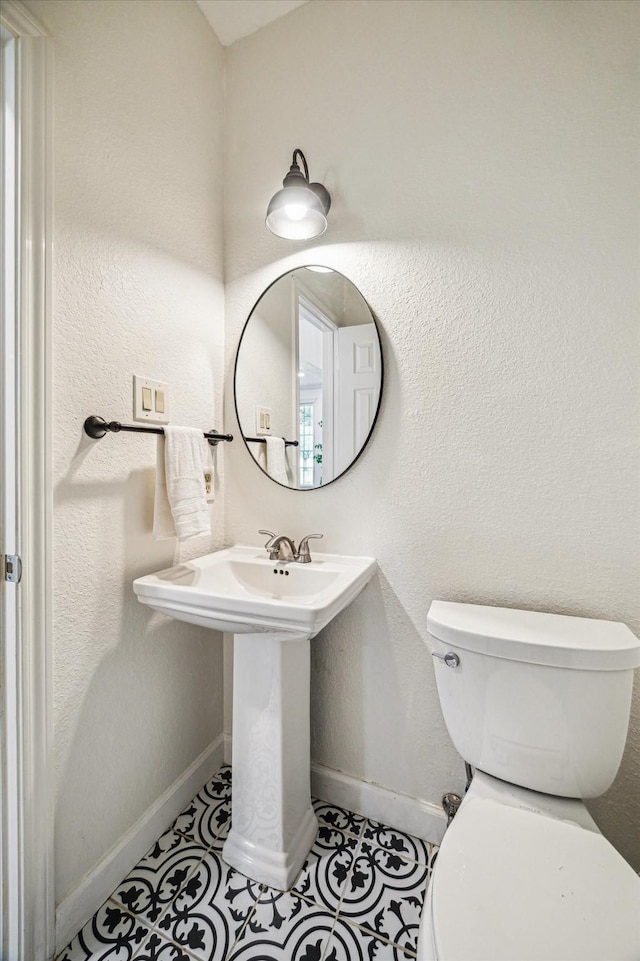 1318 N Gabriel River Cir, Sugar Land, TX 77478 - bathroom with toilet, baseboards, tile patterned flooring, and a sink