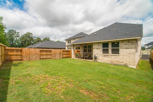 17542 Rosette Grass Dr, Conroe, TX 77385 - back of house featuring roof with shingles, a patio, brick siding, and central air condition unit