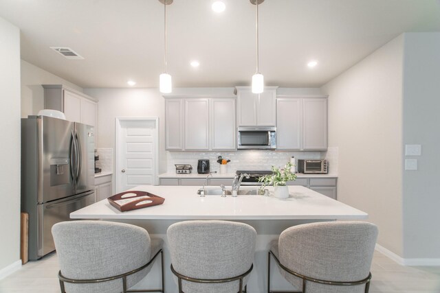 17542 Rosette Grass Dr, Conroe, TX 77385 - kitchen featuring appliances with stainless steel finishes, tasteful backsplash, light countertops, decorative light fixtures, and recessed lighting