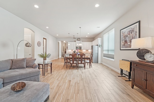 10029 Red Beadtree Pl, Conroe, TX 77385 - living room featuring arched walkways, recessed lighting, light wood-type flooring, and baseboards