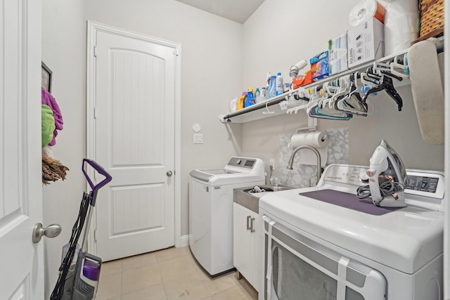 10029 Red Beadtree Pl, Conroe, TX 77385 - washroom featuring washing machine and dryer, light tile patterned flooring, and cabinet space