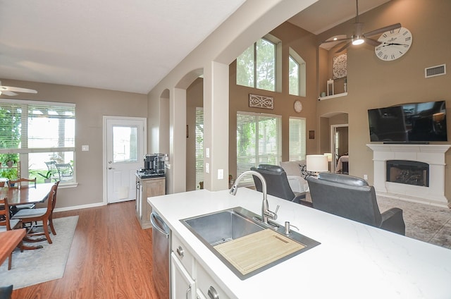 24511 Pelican Hill Dr, Katy, TX 77494 - kitchen with a ceiling fan, a sink, arched walkways, light wood-type flooring, and high vaulted ceiling