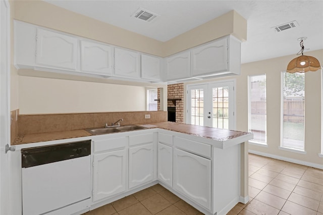 10211 Golden Meadow Dr, Houston, TX 77064 - kitchen with white dishwasher, a sink, a peninsula, light tile patterned floors, and white cabinets